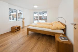 a bedroom with a bed with yellow sheets on it at Millegga Grächen in Grächen