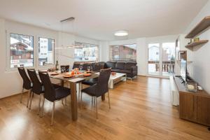 a dining room and living room with a table and chairs at Millegga Grächen in Grächen