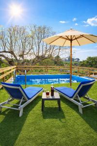 two chairs and an umbrella next to a pool at Casa Estrella in Villafamés