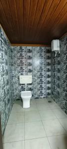 a bathroom with a toilet in a room with tiles at Agastya Beach House in Ullāl