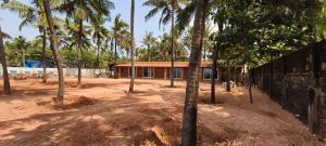 a building with palm trees in front of it at Agastya Beach House in Ullāl