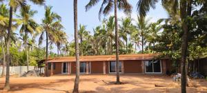 a house in the middle of palm trees at Agastya Beach House in Ullāl