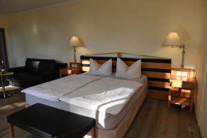 a hotel room with a large bed and a chair at Herberge 39 in Meißen