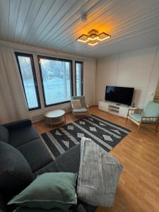 a living room with a couch and a flat screen tv at Aurora riverside home in Rovaniemi