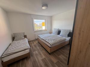 two beds in a small room with a window at Wohnung bei den Drei Gleichen #S in Wandersleben