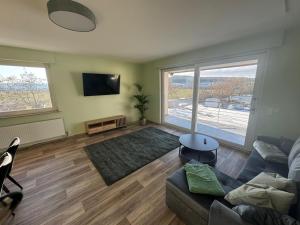 a living room with a couch and a large window at Wohnung bei den Drei Gleichen #S in Wandersleben