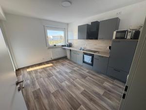 a kitchen with wooden floors and stainless steel appliances at Wohnung bei den Drei Gleichen #S in Wandersleben +2 photos