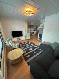 a living room with a couch and a table at Aurora riverside home in Rovaniemi +14 photos