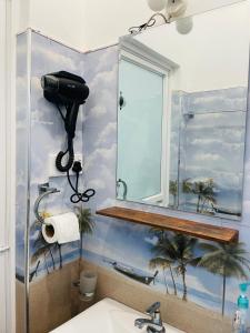 a bathroom with a mirror and a sink at Screwpine Beach Villa in Hiriketiya