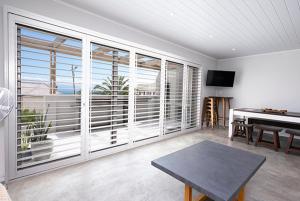 a living room with a table and a piano at Unwinding Mossel bay in Mossel Bay +19 photos