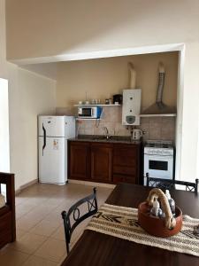 a kitchen with a table and a white refrigerator at OLÍMPICO in Concepción del Uruguay +11 photos