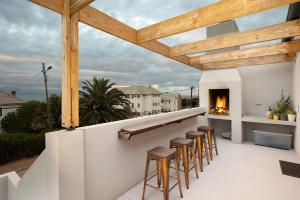 a patio with bar stools and a fireplace at Unwinding Mossel bay in Mossel Bay