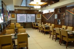 a restaurant dining room with tables and chairs at Hotel Grand Inn Jamkhandi in Jamkhandi