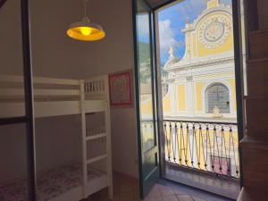 a bedroom with a bunk bed and a balcony with a clock tower at Bell' Antonio Sea View in Minori