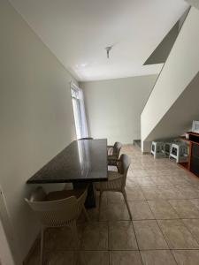 a dining room with a black table and chairs at Apartamento Praiana 303 in Guarapari