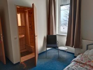 a bedroom with a door and a chair and a window at Locanda EL TORO in Arnoldstein