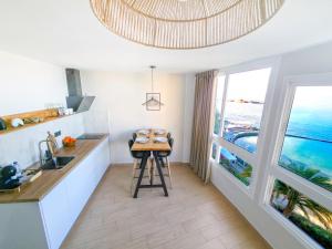 a kitchen with a table and a view of the ocean at Verana House in Arguineguín