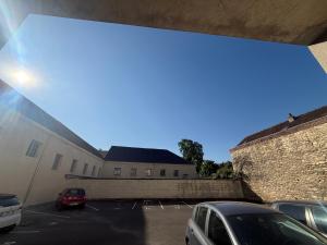 a building with cars parked in a parking lot at Studio moderne au cœur de Compiègne in Compiègne