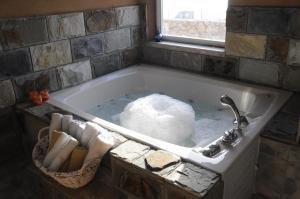 a bath tub filled with snow in a bathroom at Sanabl Druze Hospitality in Ein Kinya +117 photos