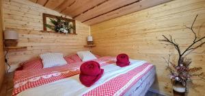 a bedroom with a bed with red towels on it at Chaloupky U Matušků in Varnsdorf