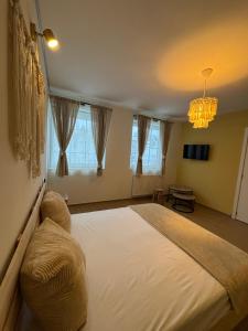 a bedroom with a large bed and a chandelier at Le Bovary Hotel Riad in Héron