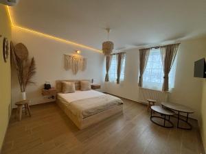 a bedroom with a bed and a table and some windows at Le Bovary Hotel Riad in Héron
