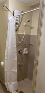 a shower with a white shower curtain in a bathroom at Avida Condo Lux Studio Unit in Iloilo City