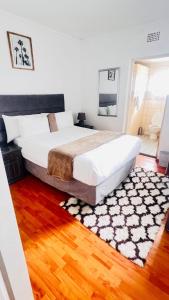 a bedroom with a large bed and a rug at Rio Lodge in Butterworth +36 photos