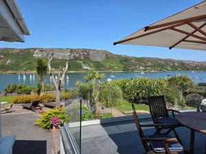 a patio with a table and chairs and a view of a lake at Anchor Haven in Goleen