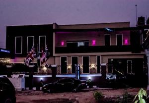 a building with a car parked in front of it at Ja'oak Hotel and Suite in Mama
