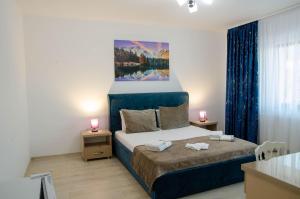 a bedroom with a king sized bed with a painting on the wall at Casa Georgia in Târgu Ocna +140 photos