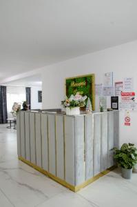 a lobby with a reception counter with flowers on it at Casa Georgia in Târgu Ocna