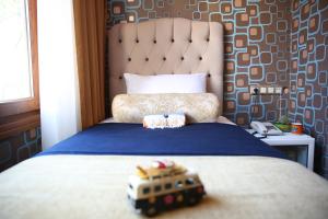 Ein Spielzeugbus sitzt auf einem Bett in der Unterkunft Kuzen Otel in Istanbul