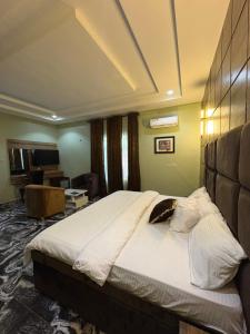a bedroom with a large bed in a room at Ja'oak Hotel and Suite in Mama