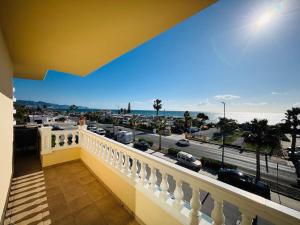 a balcony with a view of a city and the ocean at Apartamento PLAYANALA in Torrox Costa
