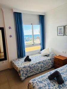 a hotel room with two beds and a window at Apartamento PLAYANALA in Torrox Costa +10 photos