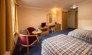 a hotel room with two beds and a desk at Loch Tummel Hotel in Tummel Bridge