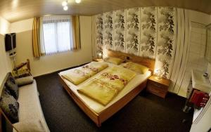 a bedroom with a large bed and a couch at White Summit Appartement in Vandans +8 photos