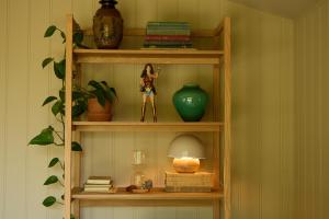 a book shelf with a doll and a lamp on it at Eyri Farm in Kjósahreppur