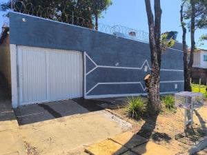 a blue building with a gate and a garage at Casa Alegria até 9 pessoas, Piscina, Churrasqueira, Empresas e Grupos in Montes Claros