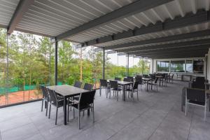 an outdoor patio with tables and chairs and windows at Sporthotel Kurz in Oberpullendorf