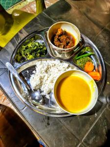 a tray of food with rice and other foods on it at Nuwakot Hills Farmstay in Trisūli Bāzār
