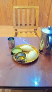 a table with a plate of pickles on a table at Apple Zone Home stay in Banjār