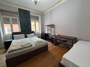 a bedroom with two beds and a desk in it at Zimmer in Kaiserslautern in Kaiserslautern