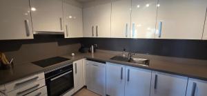 a kitchen with white cabinets and a sink at Casa Londi in Almuñécar