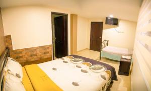 a small room with a bed and a television at Hospedaje la Cascada in Riobamba +8 photos