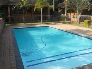 a swimming pool with blue water in a yard at Flamboyant Apartments in St Lucia