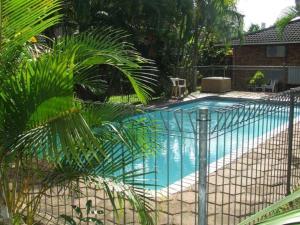 a swimming pool with a fence around it at Flamboyant Apartments in St Lucia