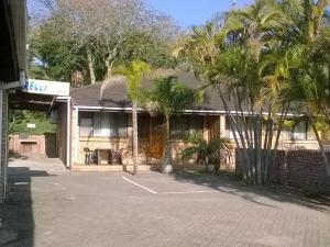 a building with palm trees in front of it at Flamboyant Apartments in St Lucia