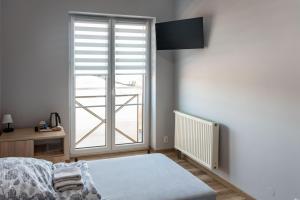a bedroom with a bed and a large window at Noclegi GCK Biała in Biała